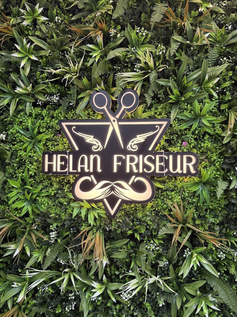Das beleuchtete HELAN-Logo auf der Pflanzenwand
